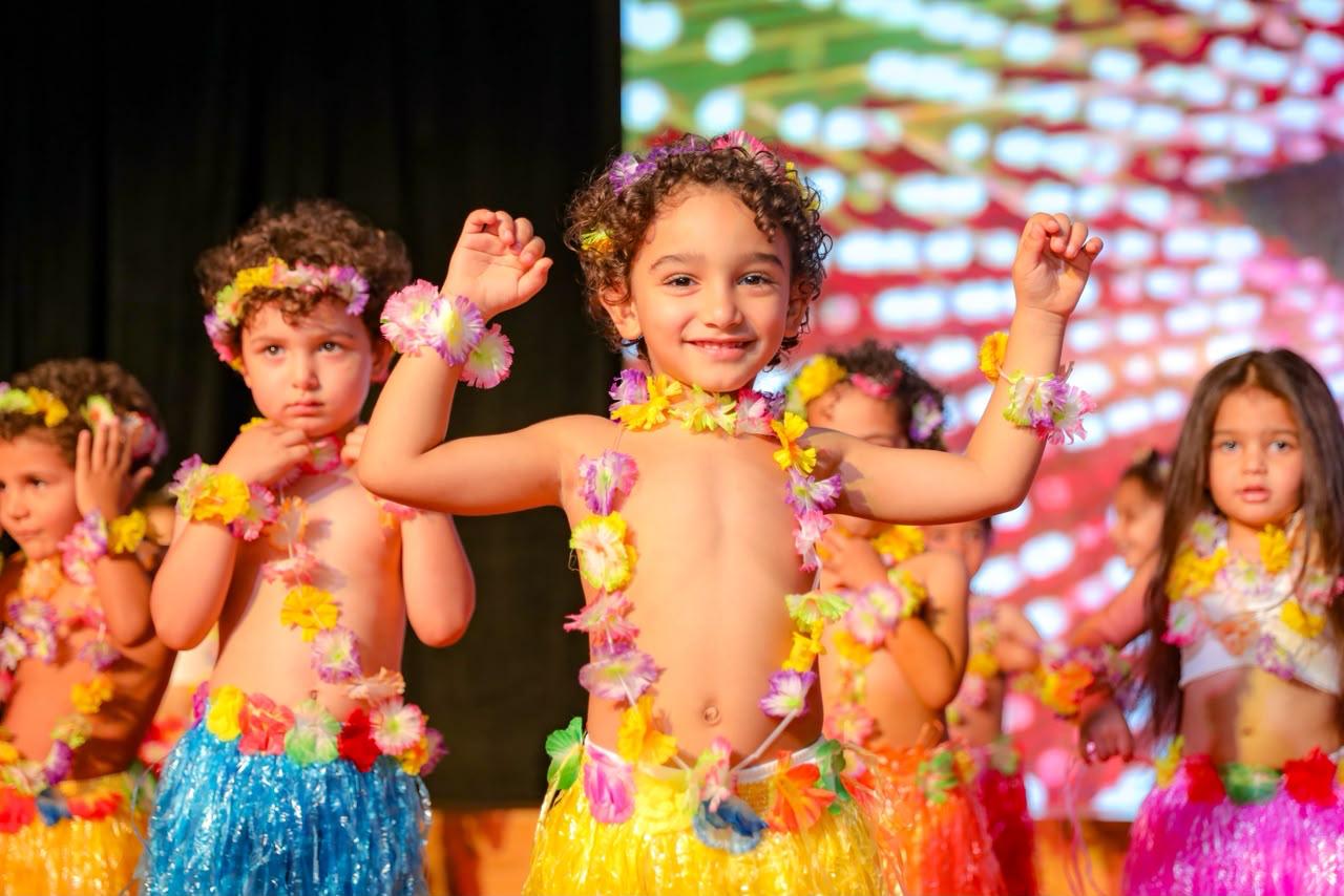 Andy Pandy children dancing in colorful floral leis during the Hawaiian performance