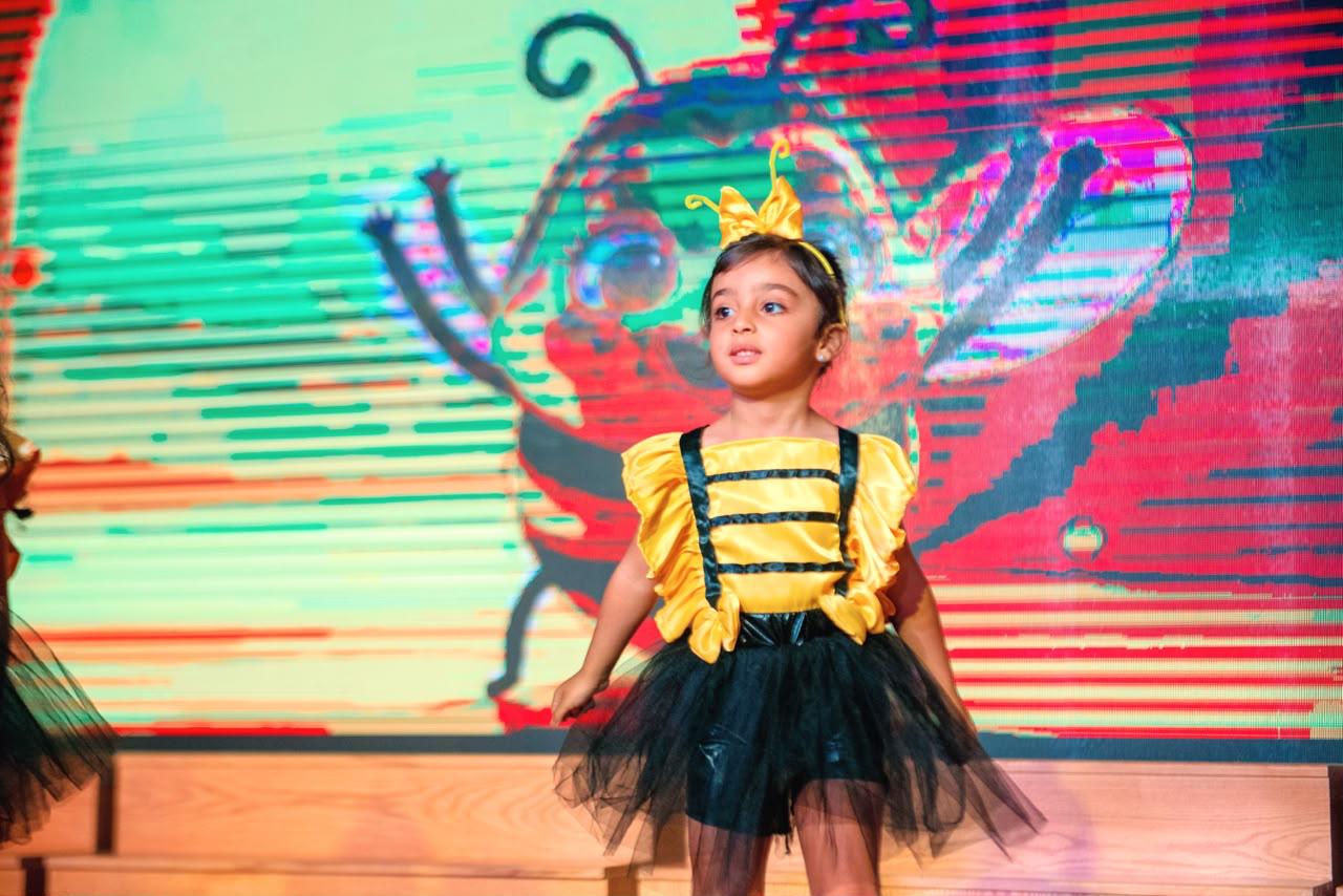 Andy Pandy graduate performing on stage in a yellow bumblebee costume
