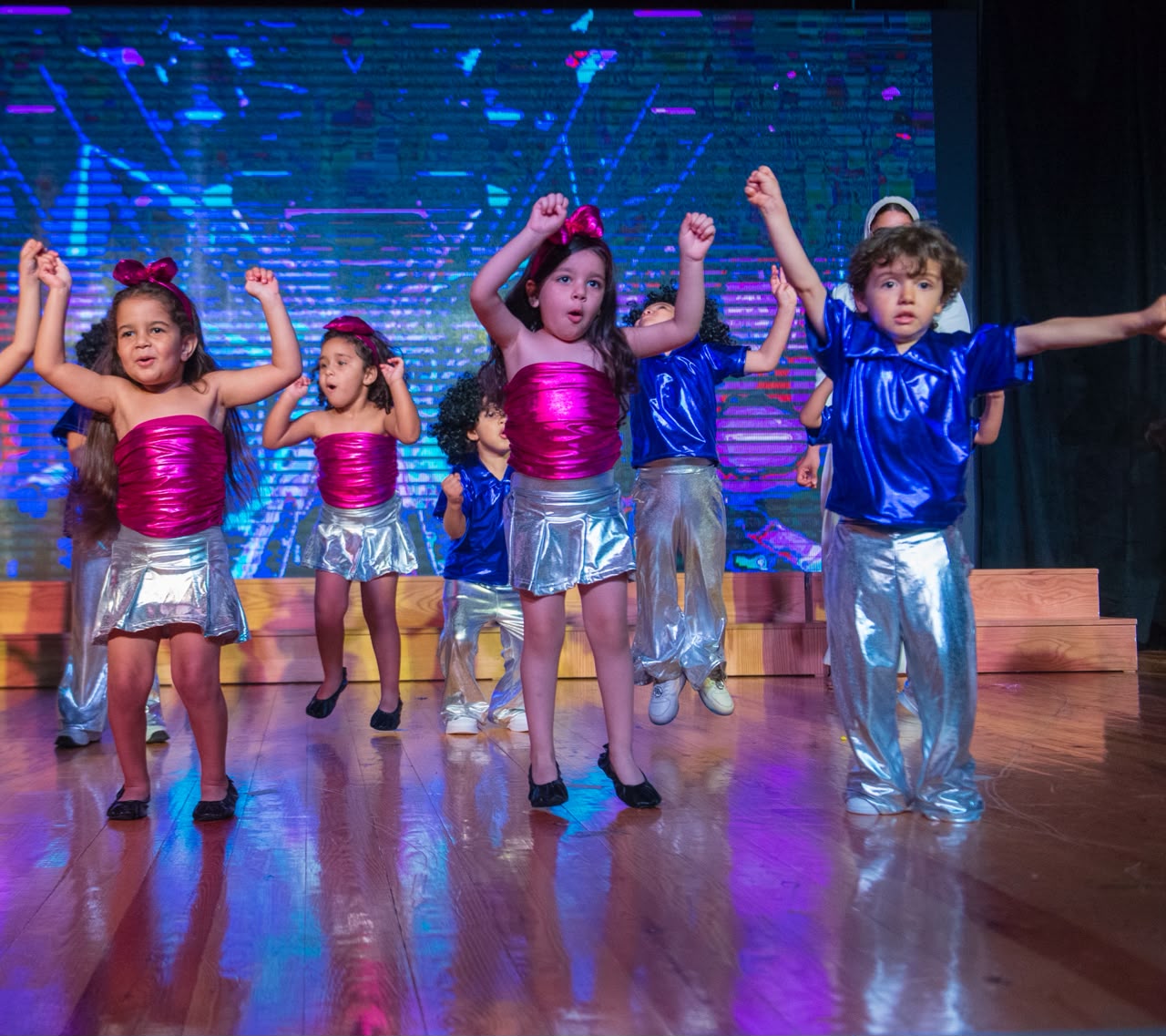 Andy Pandy graduates performing a bright disco routine in metallic silver and pink outfits